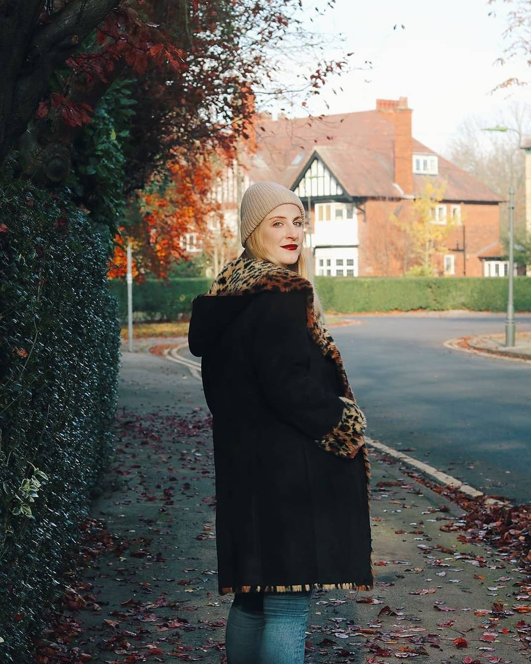 Amy walking away, looking back to camera in vintage coat