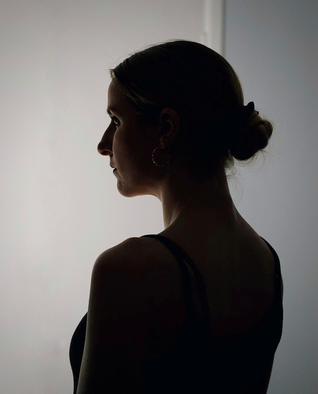 A silhouette of a woman in a black strappy top