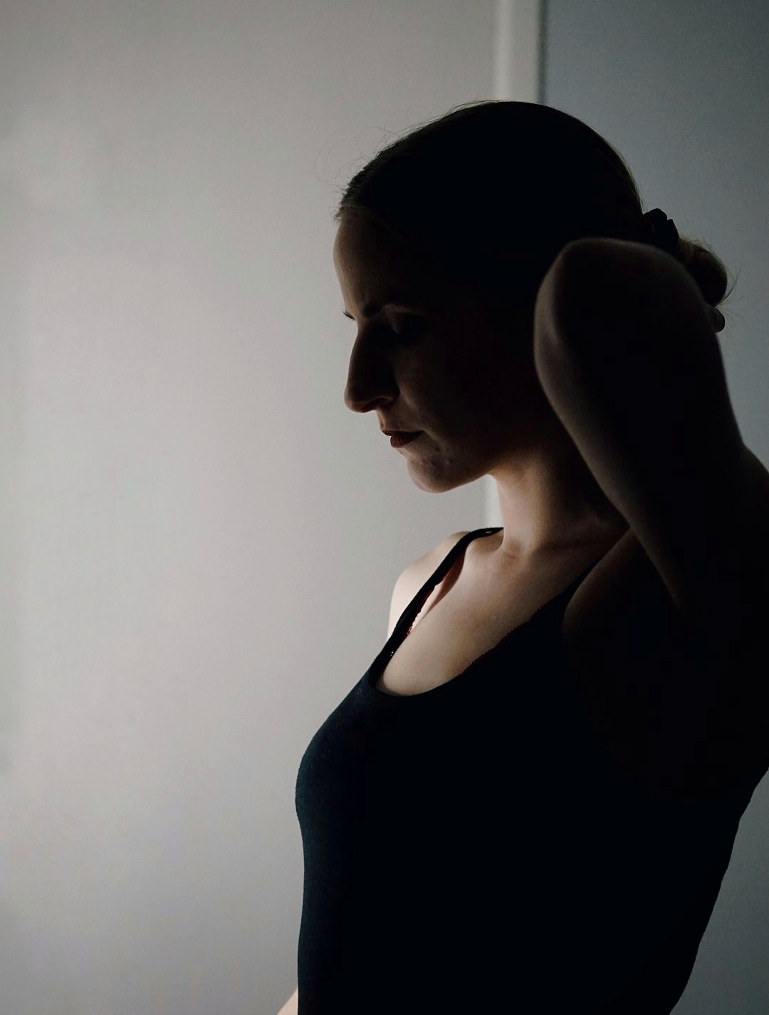 A silhouette of a woman in a black strappy top