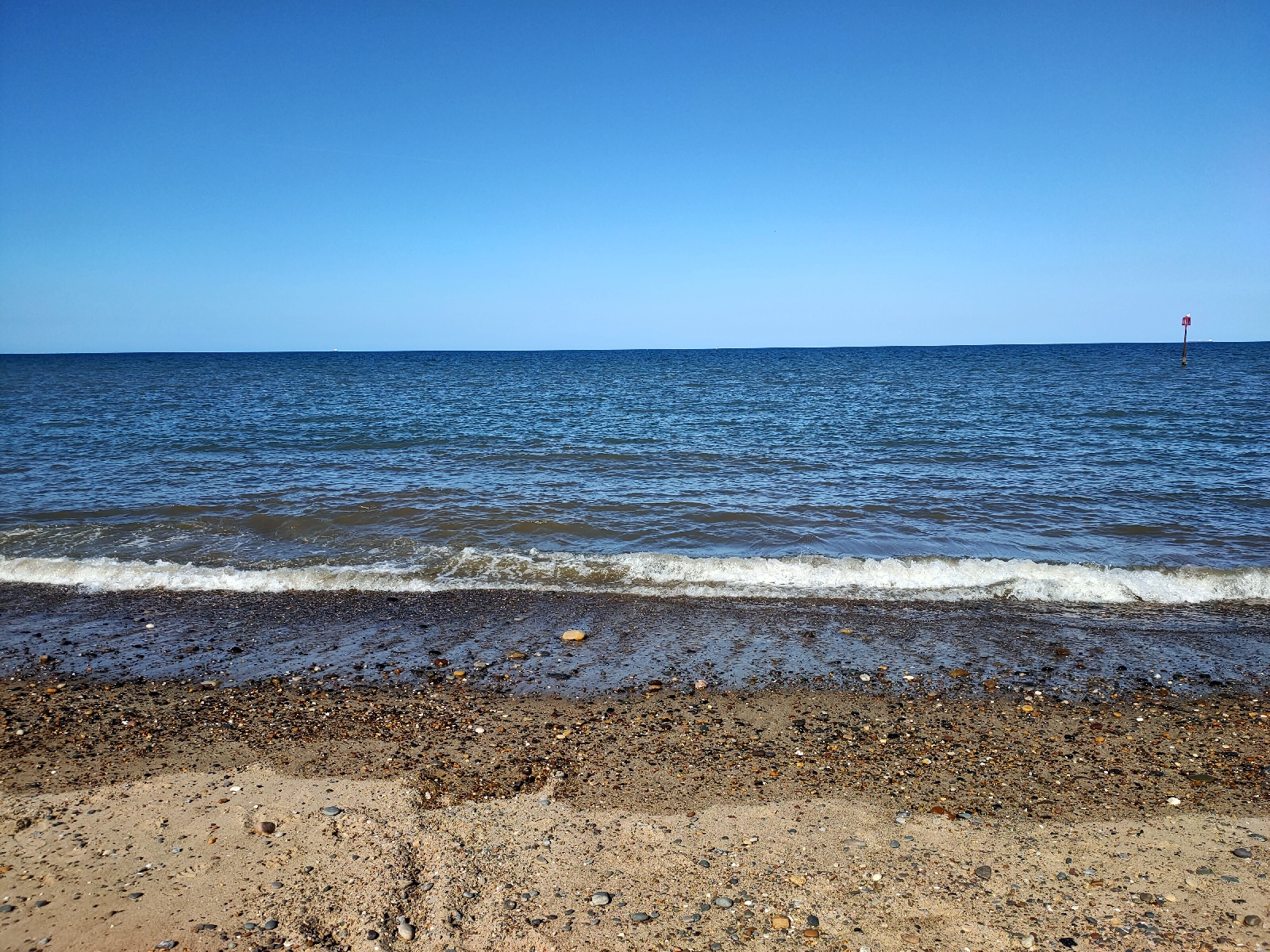 A beach, looking out to sea. Bright blue skies.