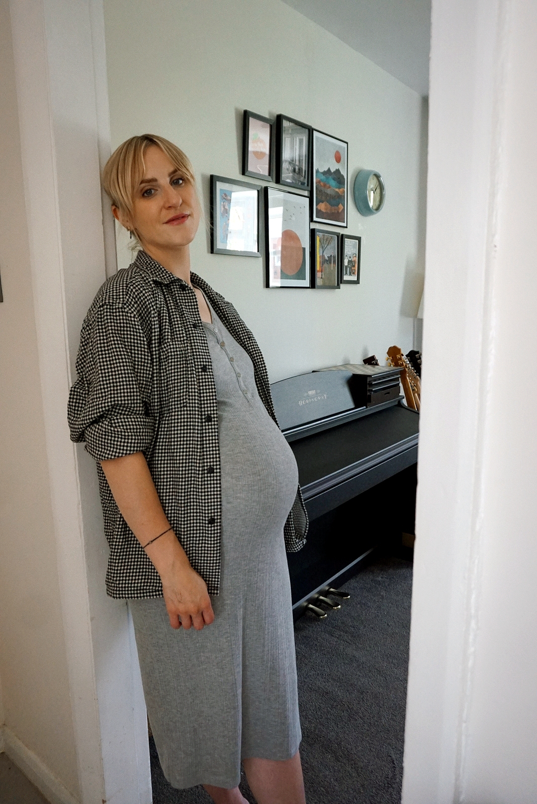 Outfit photo: Amy is stood in a doorway wearing a grey ribbed midi dress with a houndstooth shirt over the top