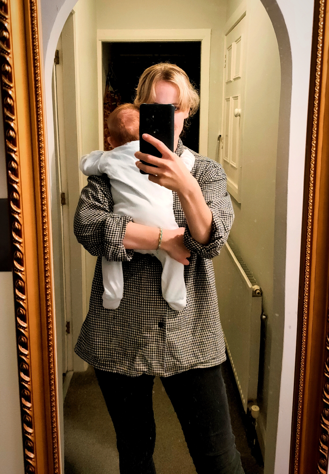 Mirror outfit selfie; wearing a black and white check shirt and black skinny jeans.