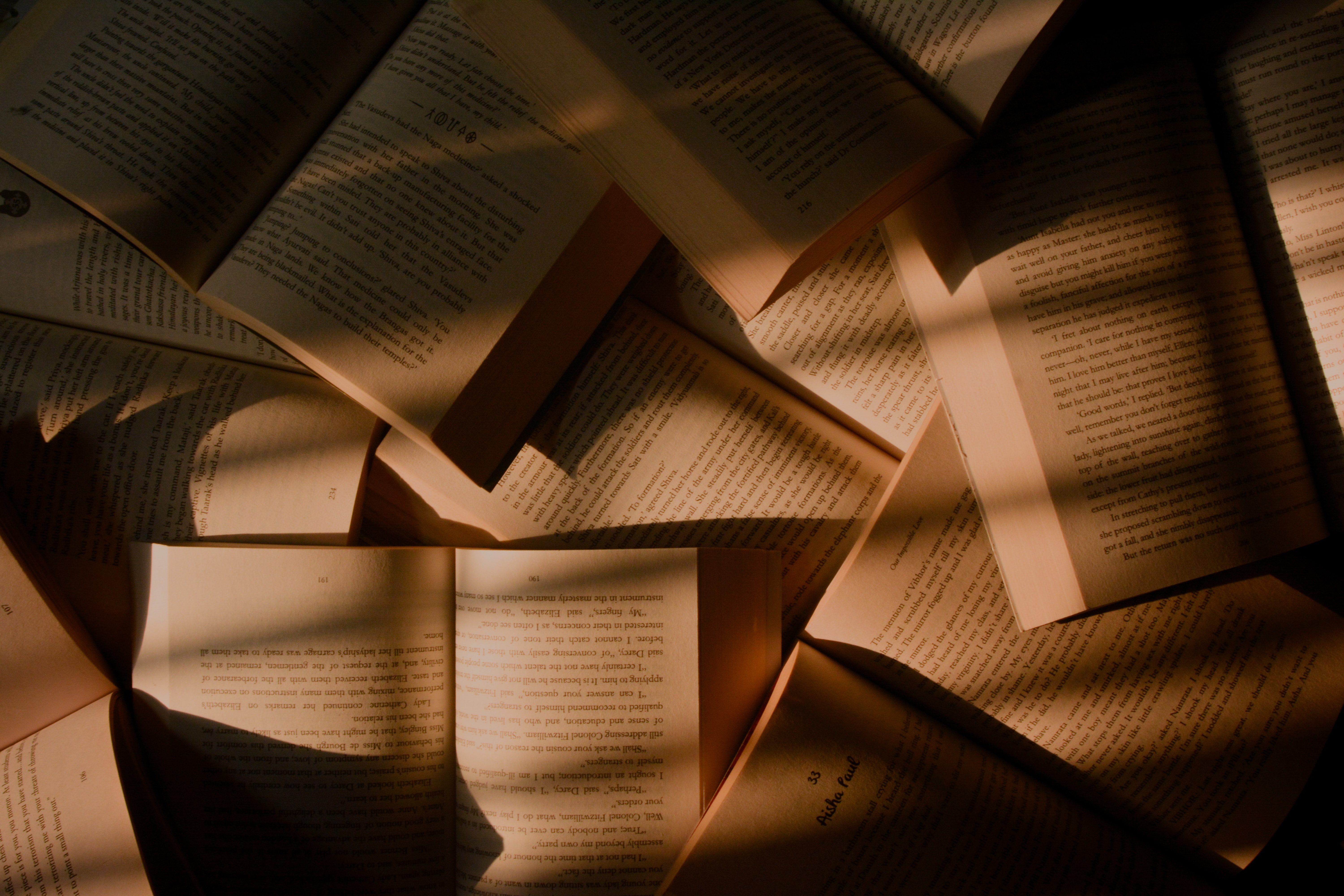 books spread out with pages on show, in shadow and light