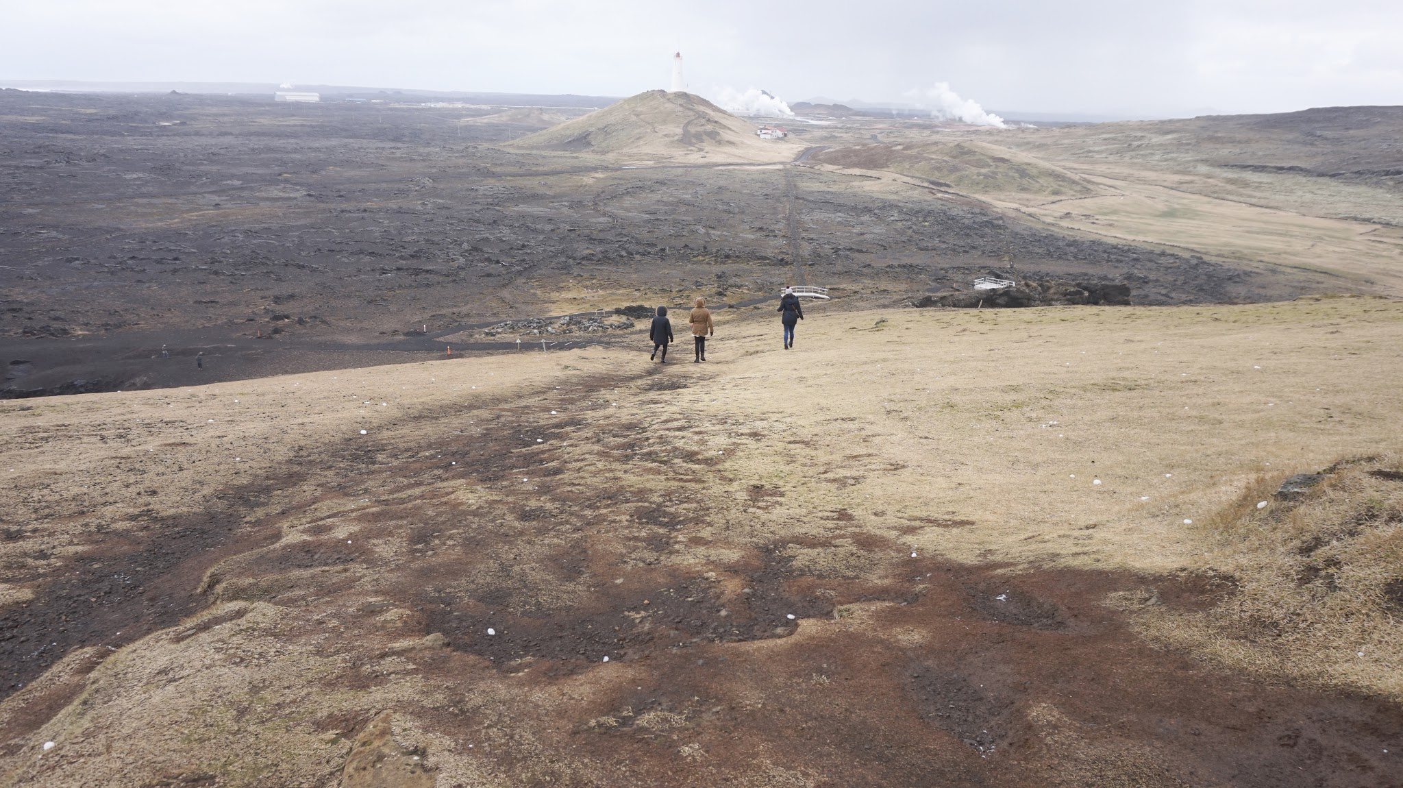 three women walking down huge hill in the middle of rural Iceland