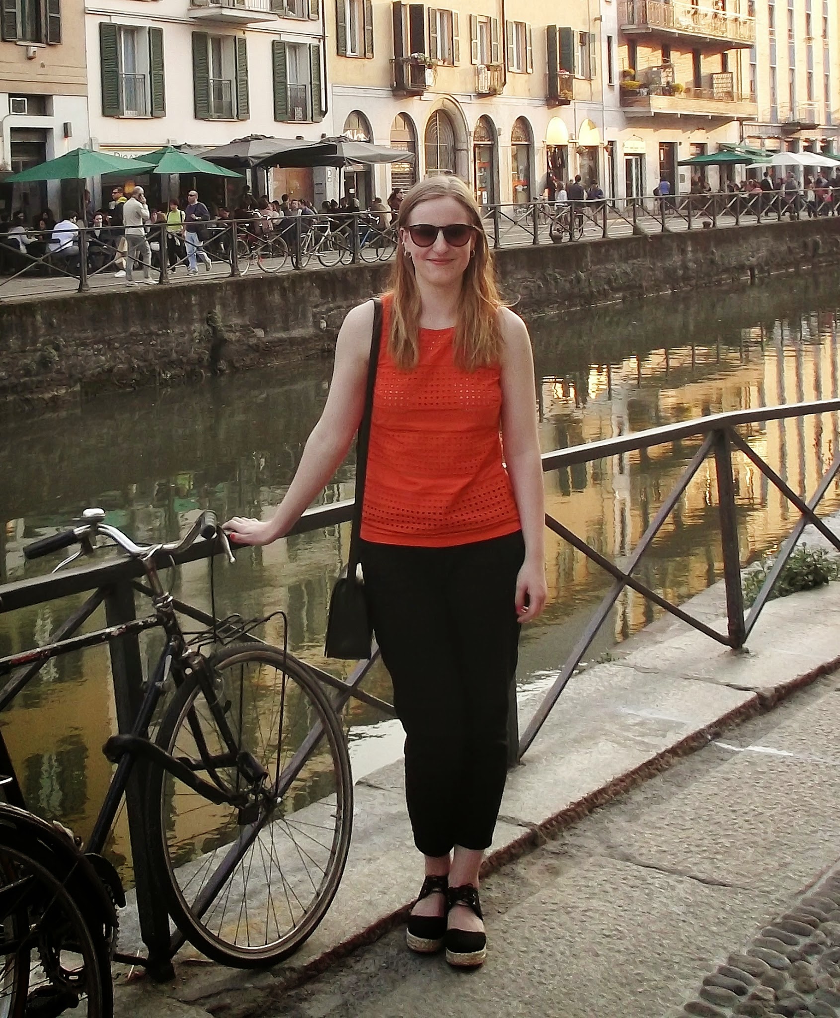 outfit: orange crochet style sleeveless top, black loose fit trousers, black platform shoes