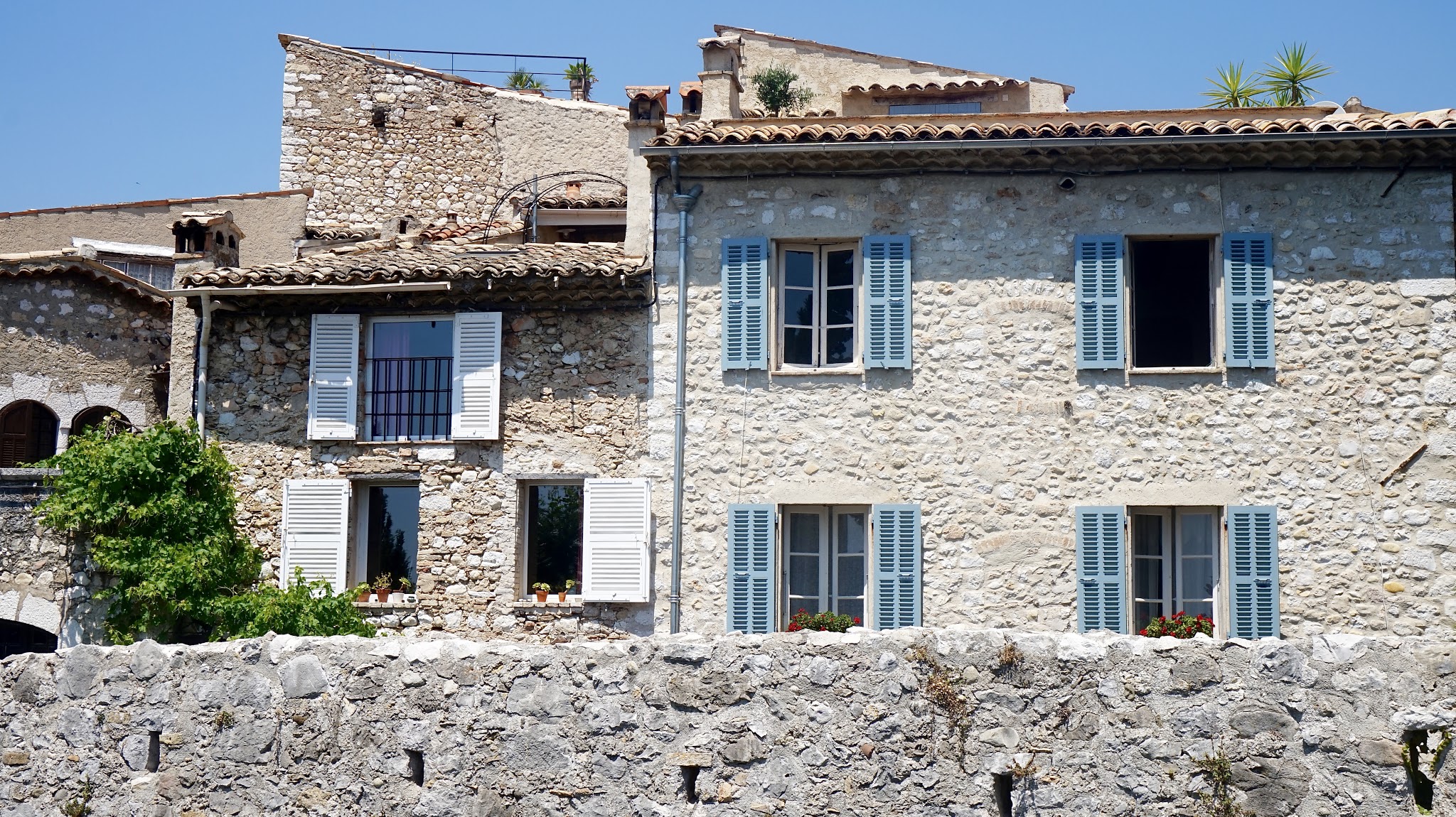 old stone houses with pale blue window shutters