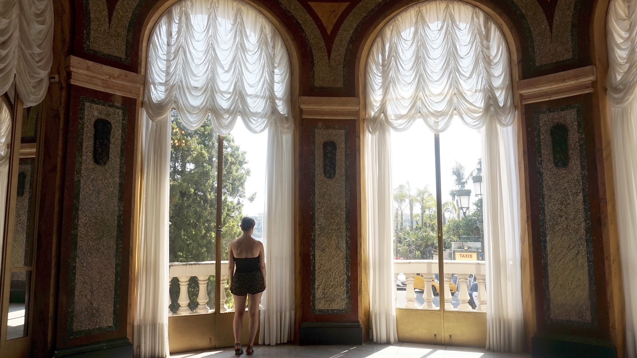 woman stood at a tall window with plush net curtains