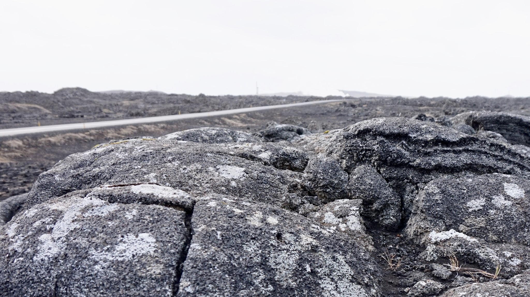 black rocks in foreground, empty road in the background